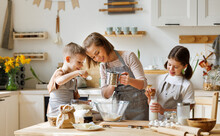 Happy Woman And Cute Children Cooking Together In Kitchen