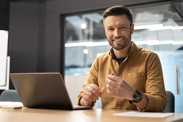 Canvas Print - Happy Businessman Sitting Near Laptop Computer Working In Office