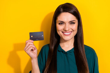 Poster - Photo of funny cute woman wear green shirt showing credit card smiling isolated yellow color background