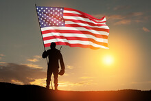 Silhouettes Of Soldier With USA Flag Against The Backdrop Of A Sunset. Greeting Card For Veterans Day, Memorial Day, Independence Day. USA Celebration. Patriotism, Protection, Remember Honor.