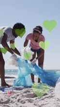 Animation Of Green Hearts Over African American Couple With Recycling Bags Cleaning Beach