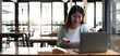 © wichayada - Happy young woman in headphones speaking looking at laptop making notes, girl student talking by video conference call, female teacher trainer tutoring by webcam, online training, e-coaching concept
