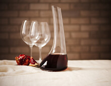 Red Wine In A Wine Decanter With Two Empty Glass And Pomegranate.