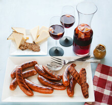 Platter Of Grilled Sausages, Cheese Plate And Glasses And Pitcher Of Sangria.