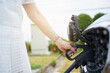 © DG PhotoStock - Unrecognizable Asian woman holding aa DC - CCS type 2 EV charging connector at EV charging station.