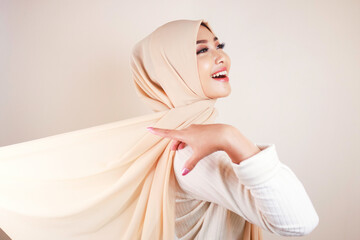 Muslim woman wearing traditional wear and hijab isolated on white background. Hijab is creatively made flying. Idul Fitri and hijab fashion concept.