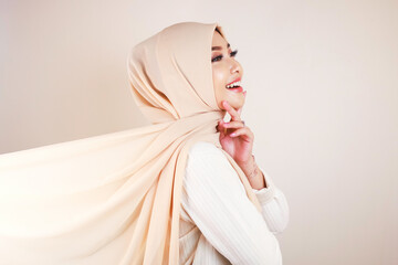 Muslim woman wearing traditional wear and hijab isolated on white background. Hijab is creatively made flying. Idul Fitri and hijab fashion concept.