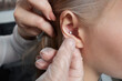 piercings on an ear. Conch and helix piercings close up. Professional holding the jewel