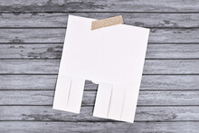 Empty White Tear-off Stub Paper Note Without Text On Wooden Wall