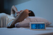 © Pormezz - woman have insomnia on the bed selective focus on alarm clock at three in the morning.