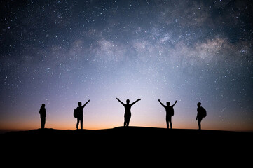 Wall Mural - Silhouette small group of young traveler and backpacker watched the star and milky way on top of the mountain with twilight sky. He enjoyed traveling and was successful when he reached the summit.