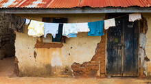 Mud Brick Home With Clothes Drying On Clothes Line, Uganda Africa