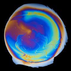 Interference colors from an oil film on water isolated on black background