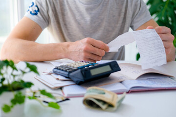 Wall Mural - a man counts a bill on a calculator on the table. payment of utility services. saving energy and mon