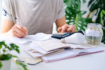 Wall Mural - a man counts a bill on a calculator on the table. payment of utility services. saving energy and mon