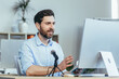 © Liubomir - Successful and happy business coach mentor, records audio podcast, uses professional microphone, businessman in modern white office, conducts online business training