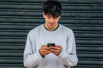 Poster - teenager or student in the street looking at the mobile phone