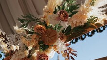 Exquisite Expensive Wedding Arch With Floral Arrangements And Mirror Ribbon. Twigs Of Artificial Flowers And Dried Flowers Sway In Wind. Sophistication Is Added By Material That Decorates Ceiling. 