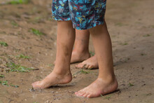 Children's Feet Treading On The Mud