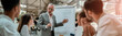 © Kostiantyn - Confident mature businessman pointing at white blackboard and explaining something to his young colleagues during meeting in the office
