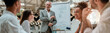 © Kostiantyn - New business strategy. Mature businessman standing near whiteboard and explaining something to his colleagues