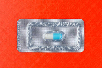 Wall Mural - Blister of one very important and expensive tablet or pill. Red background