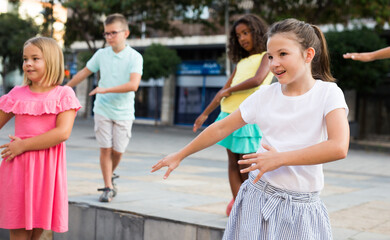 Wall Mural - Young boys and girls dancing outdoors. They're performing street dance moves and having fun.