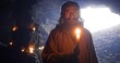 © procinemastock - Elderly hermit with candle examining dark cave