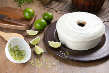 Wall Mural - Moist lemon fruit cake on plate with lemon slices on wooden table. Delicious breakfast, traditional tea time. Lemon cake recipe.