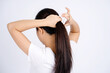 © PBXStudio - Asian woman tying her hair up isolated on a white background.