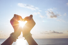 Heart Shape Making Of Hands Against Blue Sky And Sun