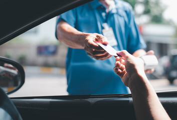 Young Asian . man driving car hand holding credit card payment for gasoline at petrol station. Traveler man car owner paying fuel pump with credit card, customer mileage point loyalty reward concept.