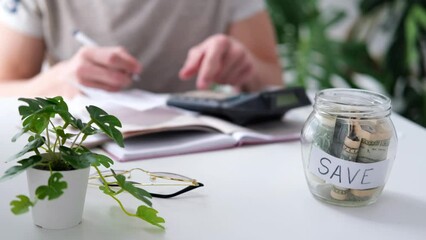 Wall Mural - a man counts a bill on a calculator on the table. payment of utility services. saving energy and mon