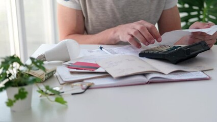 Wall Mural - a man counts a bill on a calculator on the table. payment of utility services. saving energy and mon