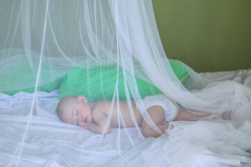 Baby girl sleeping under mosquito net