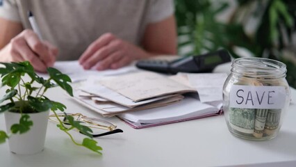 Wall Mural - a man counts a bill on a calculator on the table. payment of utility services. saving energy and mon