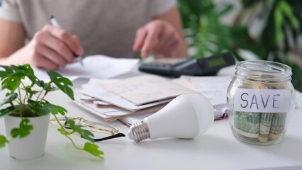 Wall Mural - a man counts a bill on a calculator on the table. payment of utility services. saving energy and mon