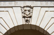 Brescia. Closeup of Medieval Broletto Palace (Palazzo Broletto or Palazzo del Governo), XII-XXI century. White stone arch with keystone and a gargoyle grotesque human mask.  Lombardy, Italy, Europe.