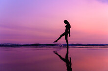 Silhouettte Photo Of Young Beautiful Asian Woman With Bikini Walking Along Beautiful Beach At Twilight Sunset Time. Happy Or Freedom Woman Concept.