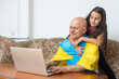 © Angelov - Grandfather and granddaughter with laptop and flag of Ukraine