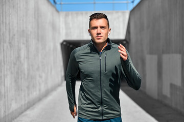 Wall Mural - fitness, sport, training and lifestyle concept - young man with wireless earphones running outdoors