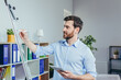 © Liubomir - Young businessman writing on white board with marker business strategy plan, man working in modern bright office