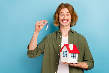 Canvas Print - Portrait of attractive cheerful guy holding house flat key rent service bank credit isolated over pastel blue color background