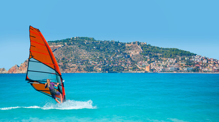 Wall Mural - Beautiful blue sky with windsurfer surfing the wind on waves - Alanya, Turkey