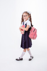 little girl in glasses and a school uniform holds a book  isolated on a white background