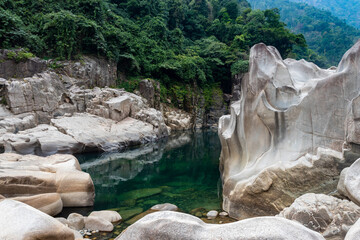 river water with naturally formed white shiny stone in unique shape at dry river bed at morning