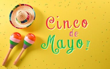 Wall Mural - Cinco de Mayo holiday background made from maracas, hat and the text on yellow background.