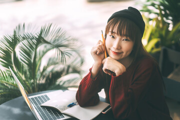 Wall Mural - Young adult asian college student woman with laptop for study at cafe on day