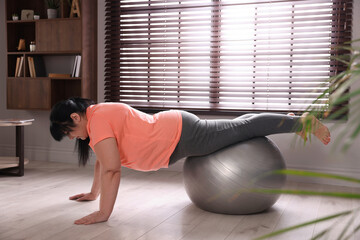 Sticker - Overweight mature woman doing exercise with fitness ball at home