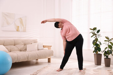 Poster - Overweight mature woman stretching at home, space for text